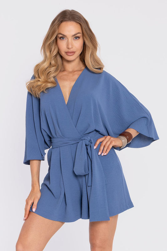 Woman wearing a blue romper on a white background