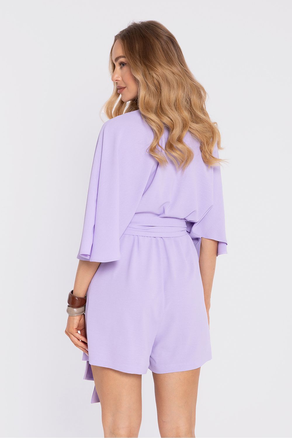 Woman wearing a light purple romper on a white background