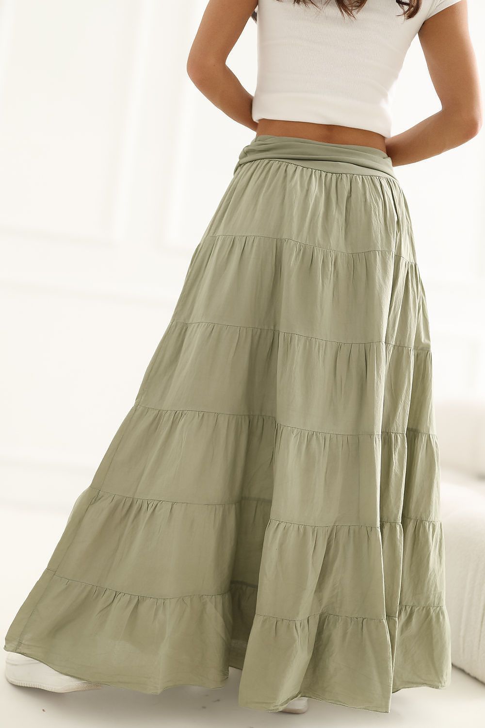 Green tiered skirt worn by a person on a white background