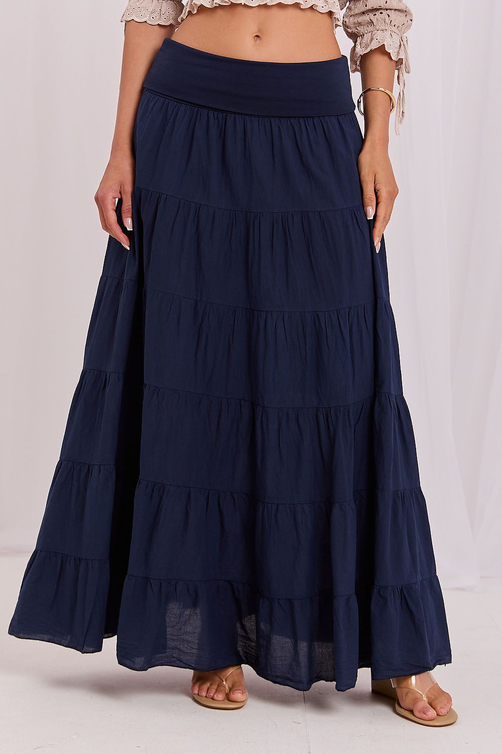 Navy blue tiered maxi skirt worn by a person on a white background