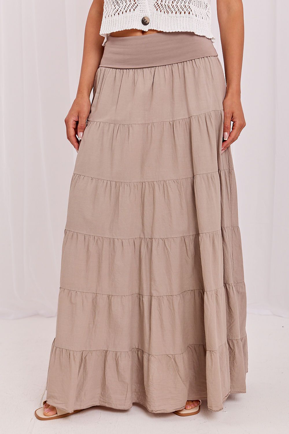 Beige tiered skirt worn by a person on a white background