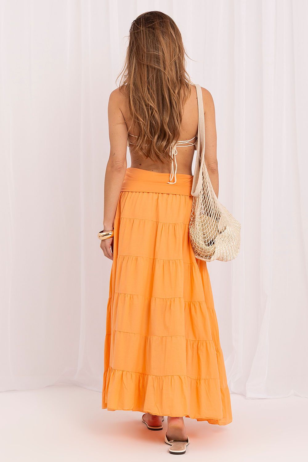 Woman wearing an orange skirt with a white background