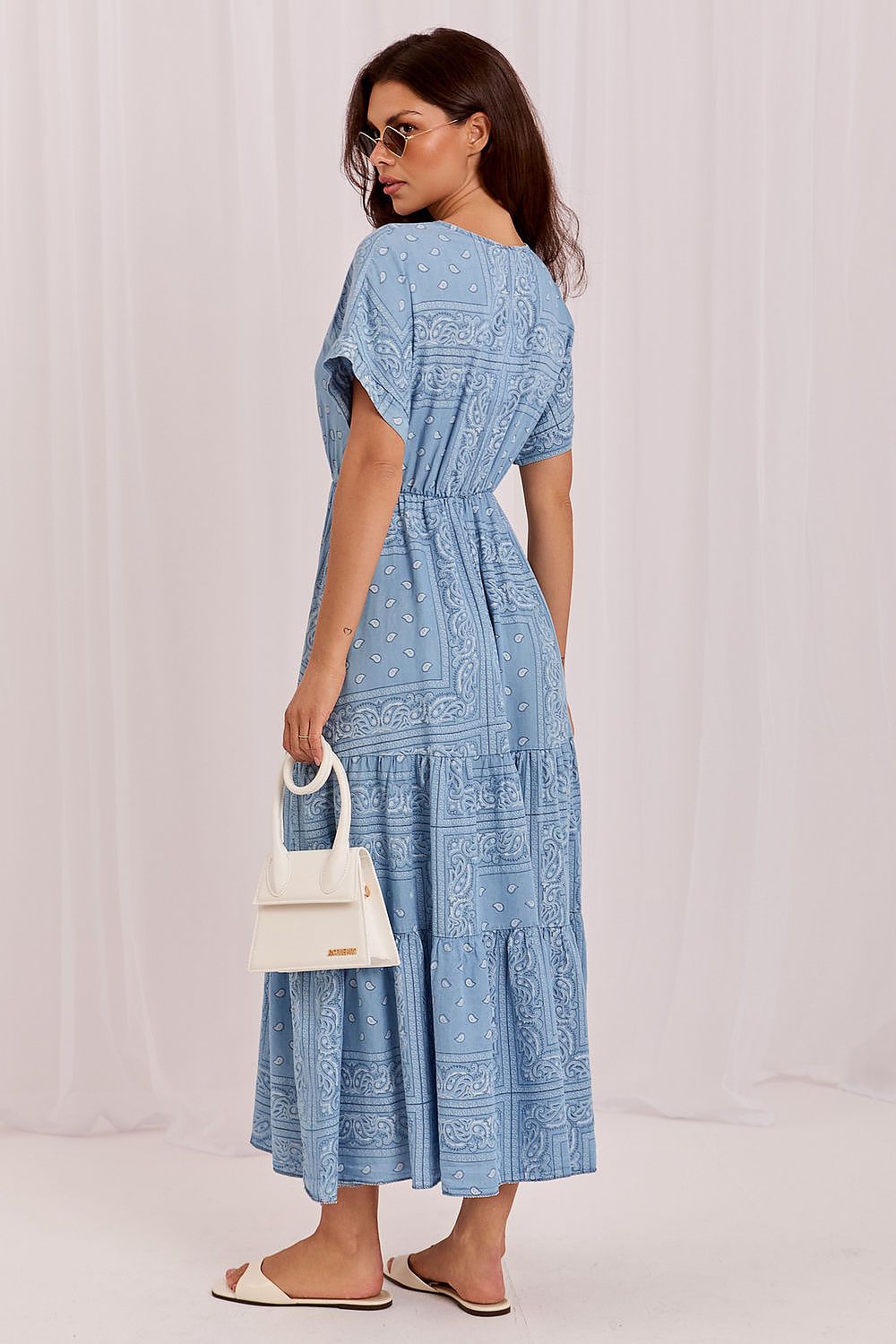 The Sienna Breeze Maxi Dress in blue featuring a flattering wrap neckline and flowing printed maxi skirt-rear view