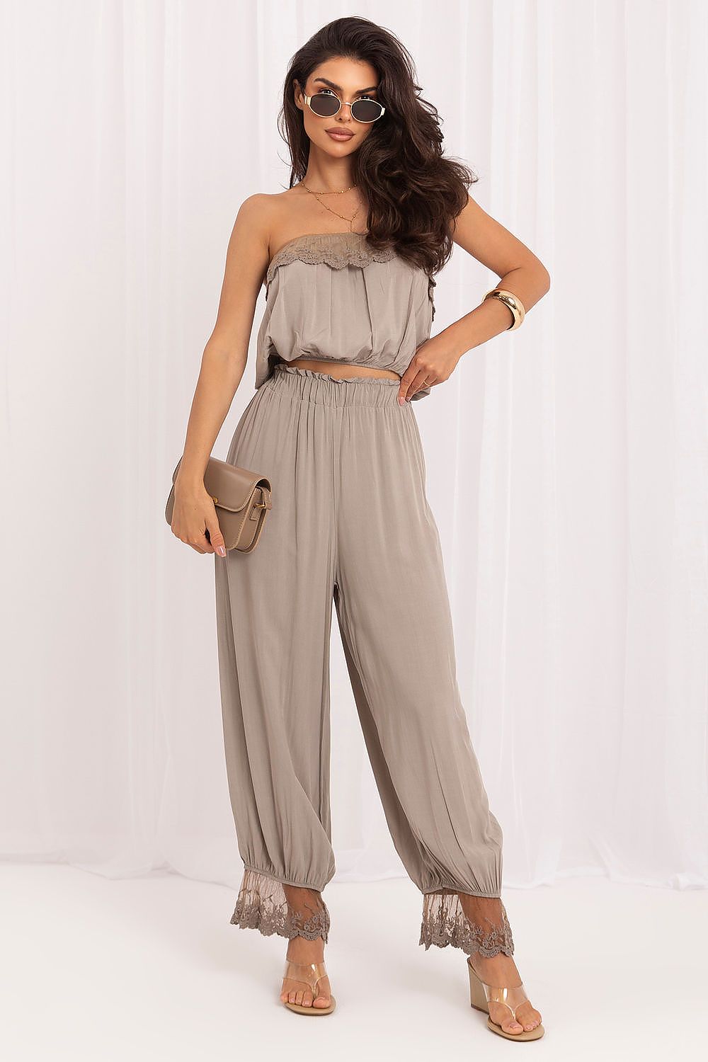 The Capri Lace Co-Ord Set in beige featuring a lace-trimmed crop top and matching full-length trousers