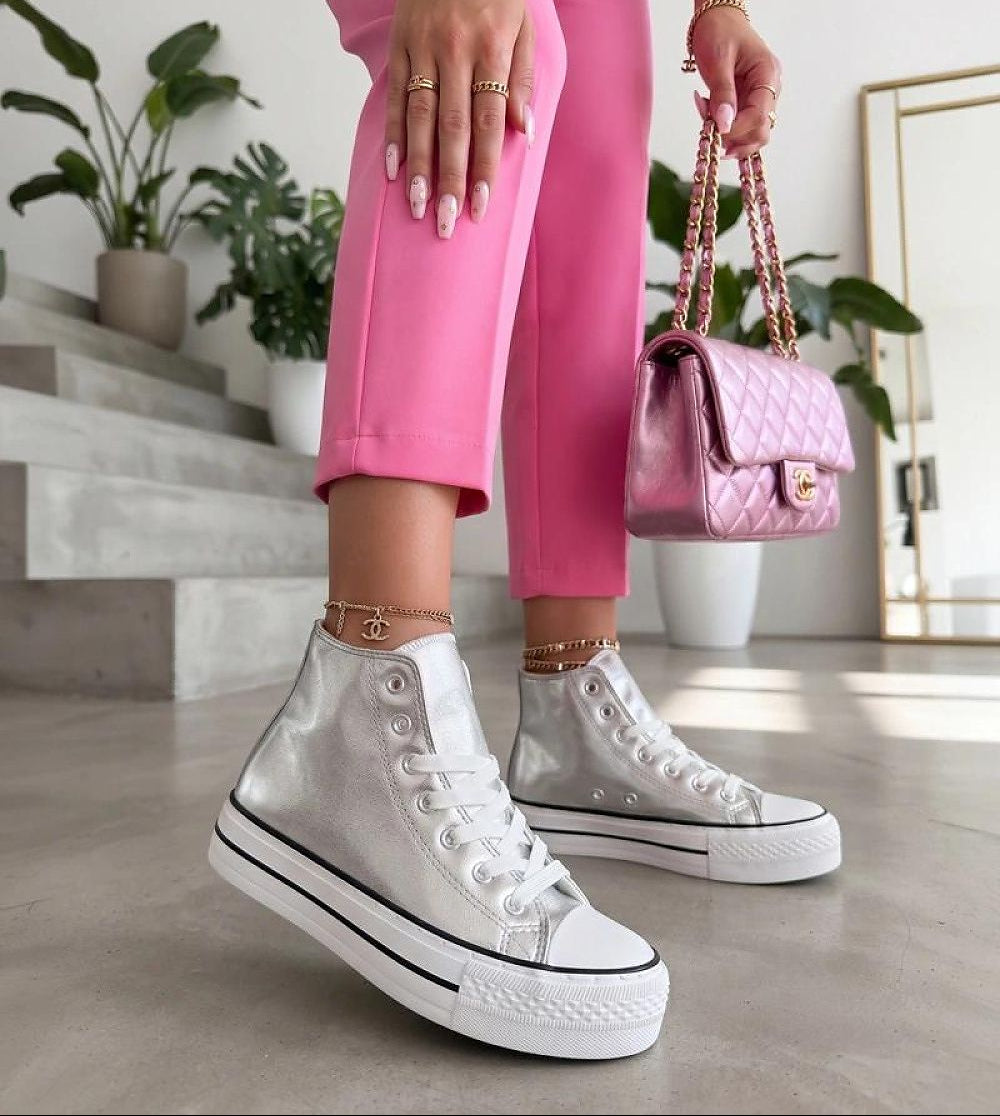  Women's silver metallic high-top platform sneakers with lace fastening.