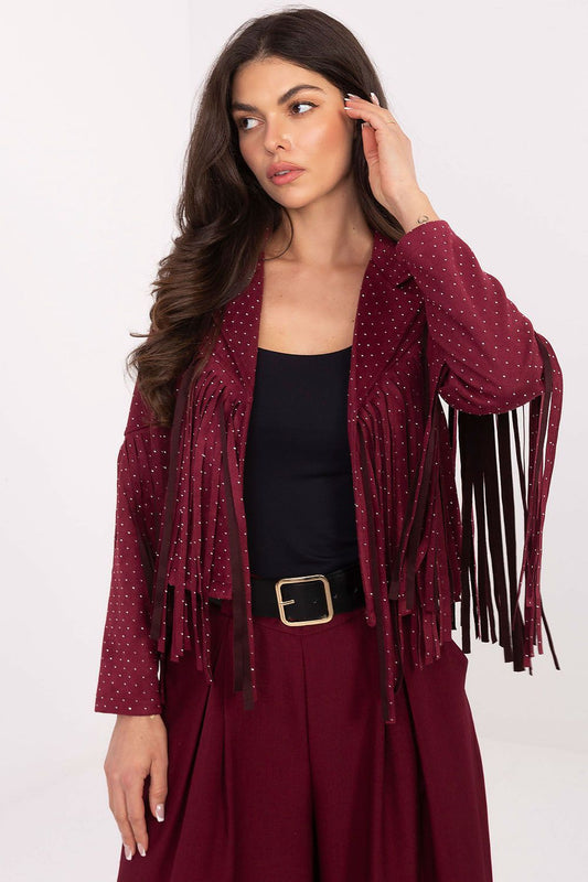A woman models a burgundy fringed jacket with small white polka dots, worn over a black top and matching burgundy pants against a plain white studio background.