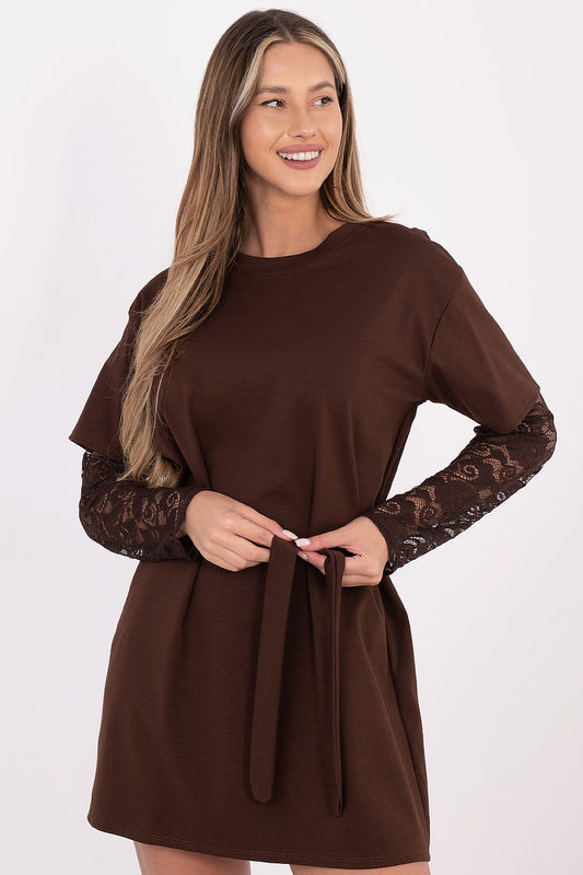 A woman modeling a brown long-sleeve dress with a solid crew neck and waist tie, featuring sheer lace sleeves, against a plain white background.
