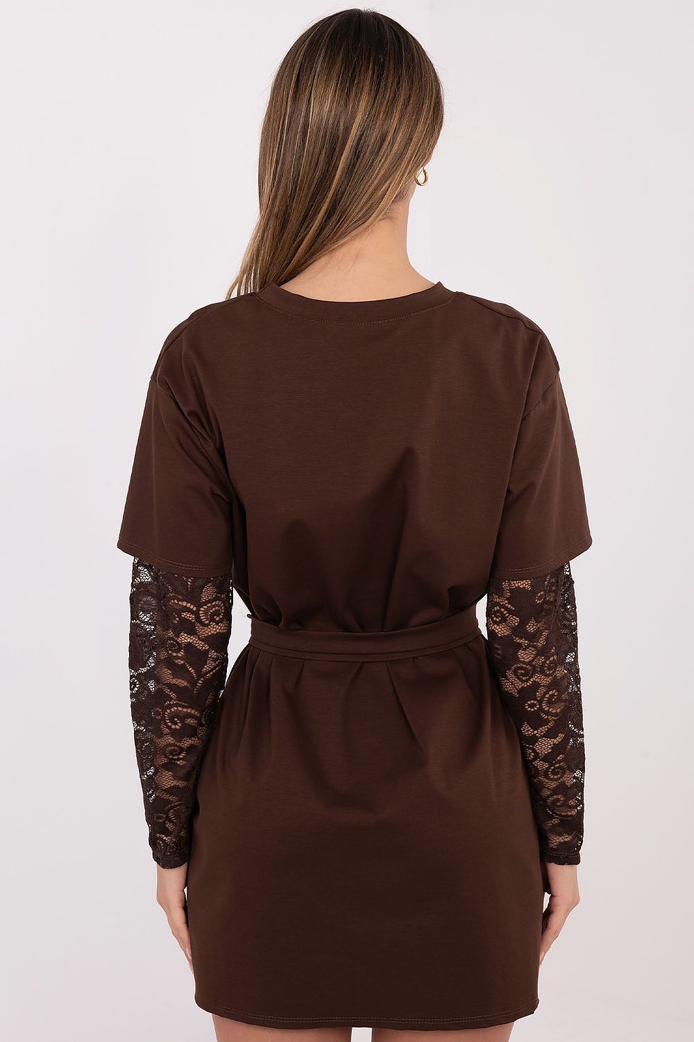 A woman viewed from the back wearing a brown short-sleeve dress with sheer lace long sleeves and a matching fabric tie belt at the waist, against a plain light background.