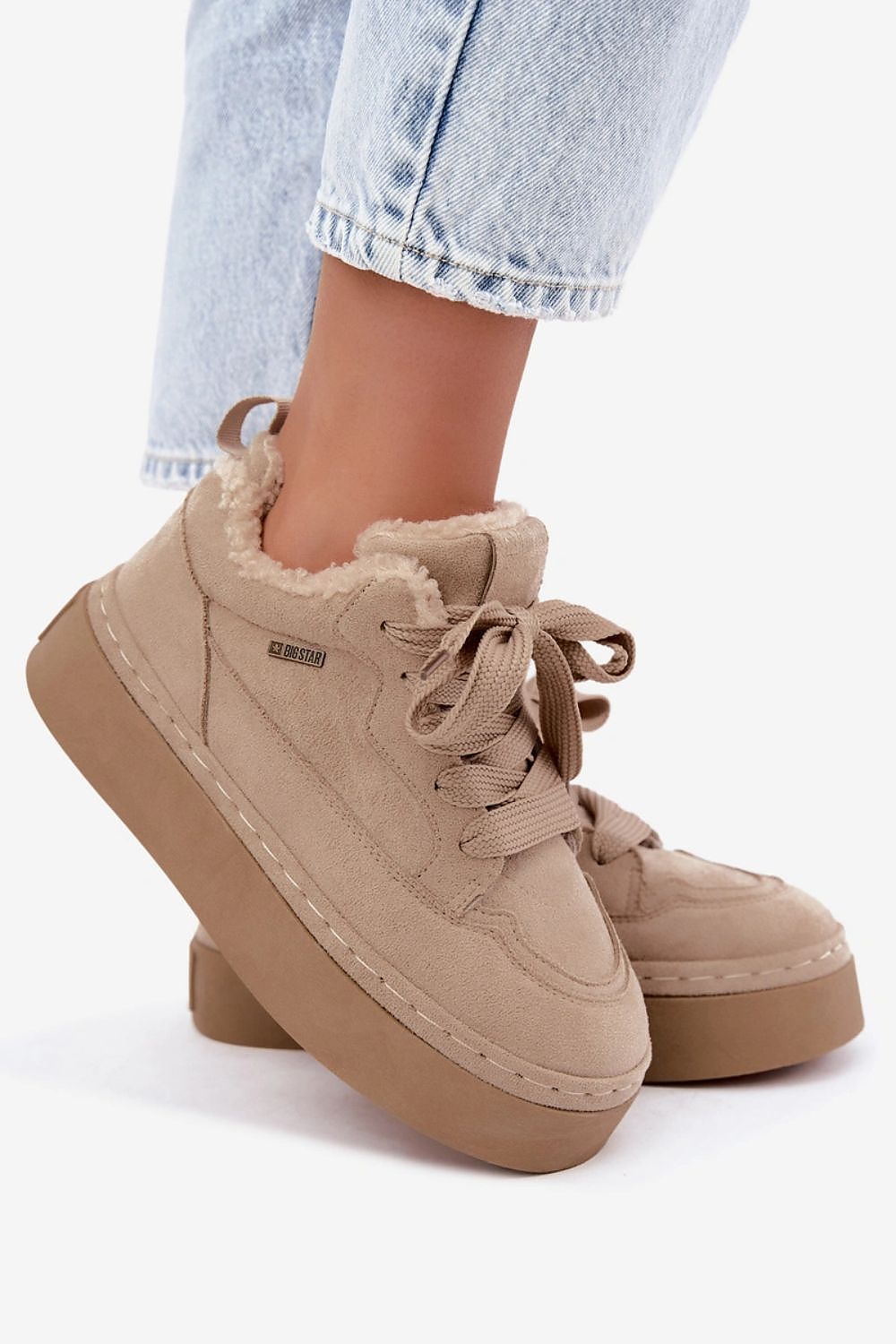 Beige platform low-top sneakers with a fuzzy shearling-style collar, shown worn with light-wash blue jeans against a clean white background.