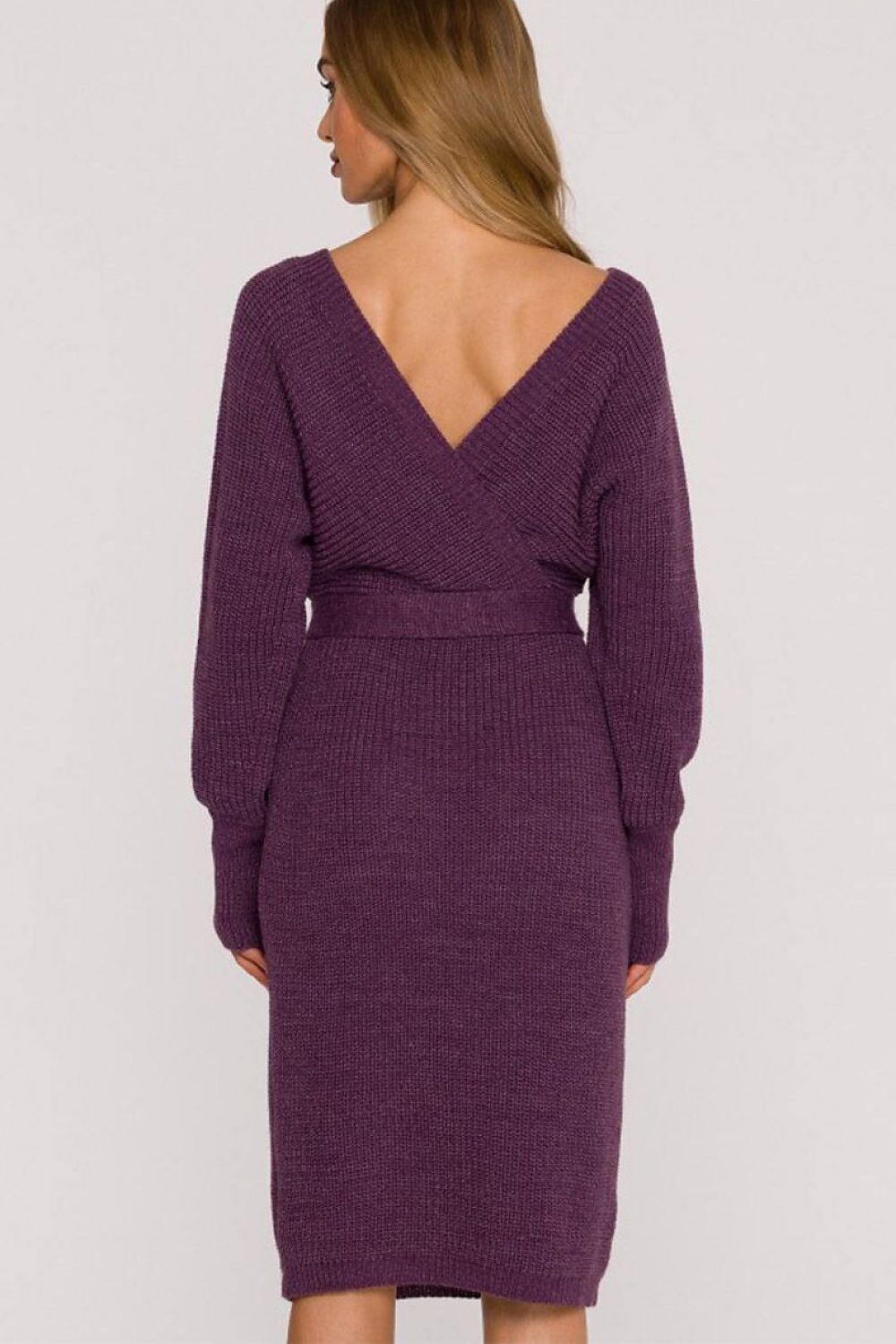 A woman wearing a ribbed knit wrap-style midi dress in a deep plum purple, shown from the back against a light gray studio background.