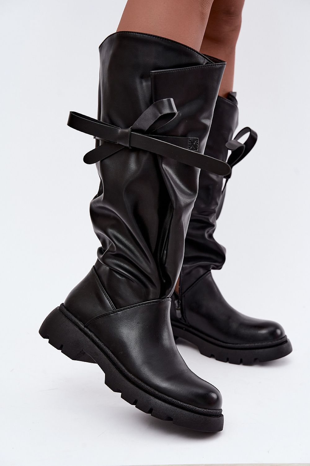Women's black eco-leather boots with relaxed shaft and decorative bow tie
