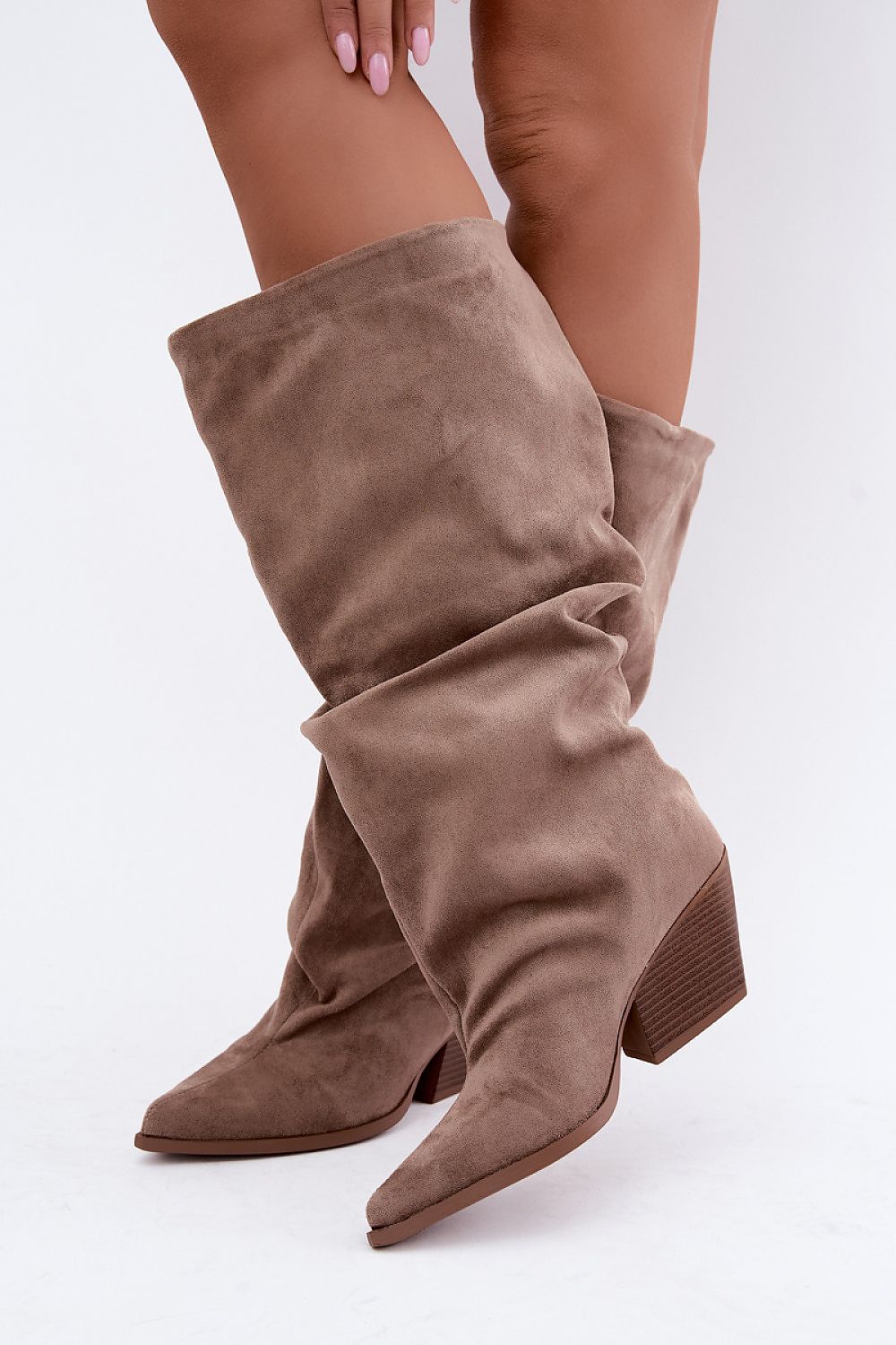  Beige gathered-shaft boots with a feminine block heel, styled with fitted trousers for a polished everyday outfit.