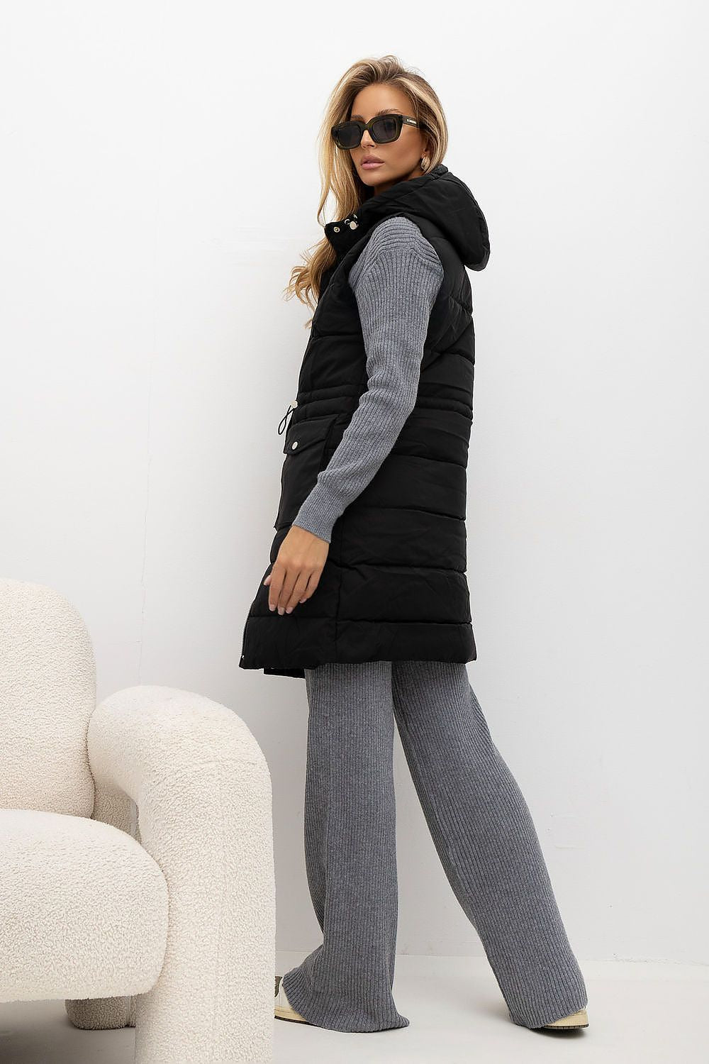 Women's black knee-length quilted gilet with hood and stand-up collar rear view