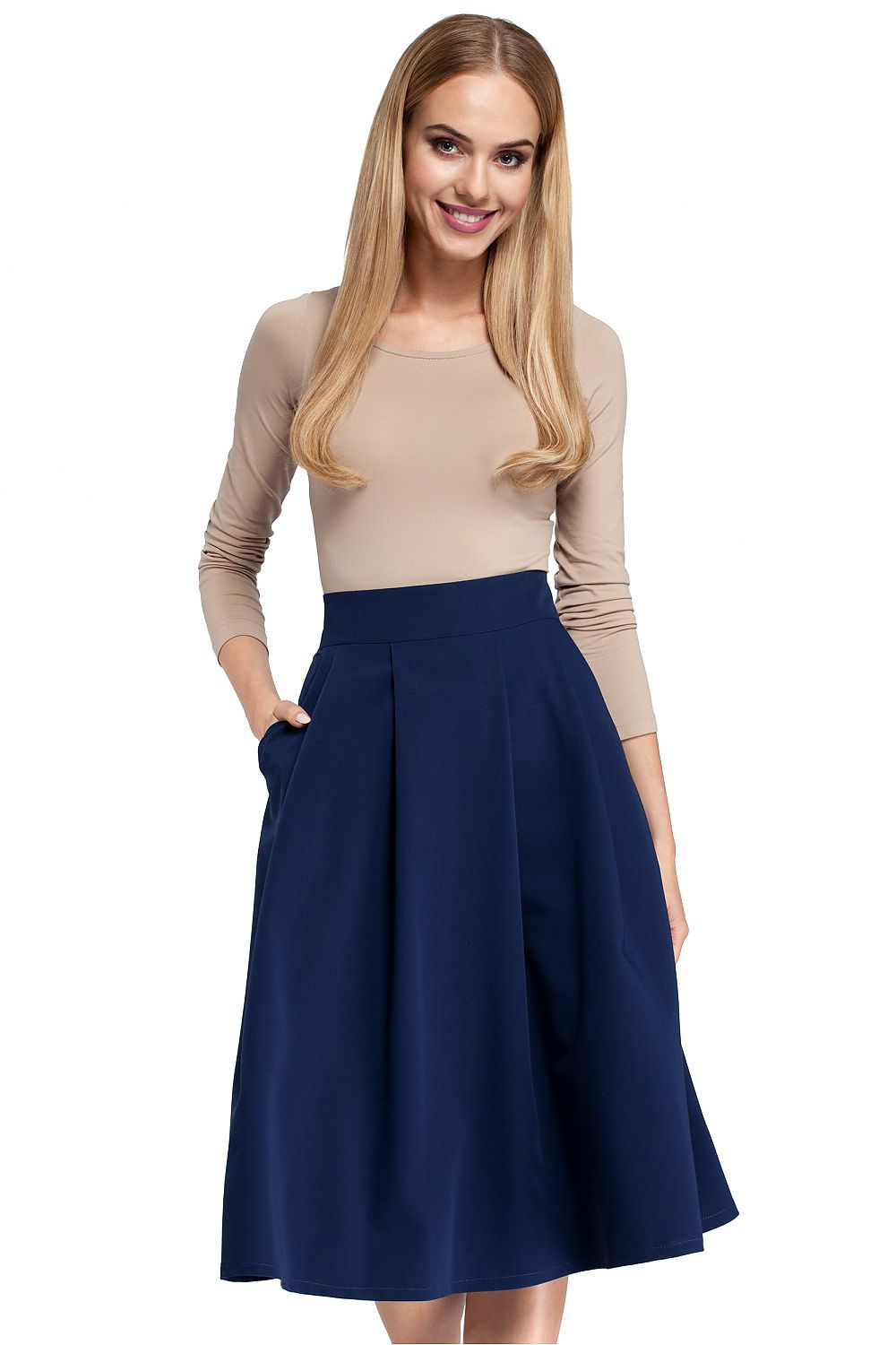 Woman wearing a beige top and navy blue skirt on a white background
