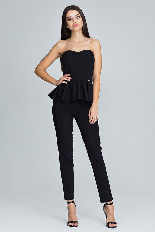 Woman wearing a black strapless top and black pants on a gray background