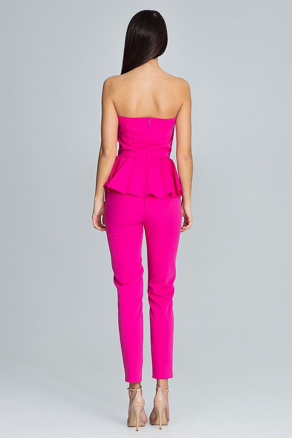 Person wearing a bright pink strapless top and pants on a gray background