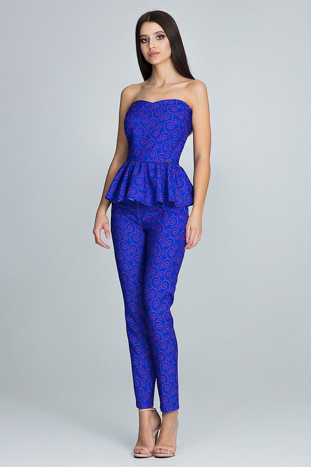Woman wearing a blue strapless top and pants set on a gray background