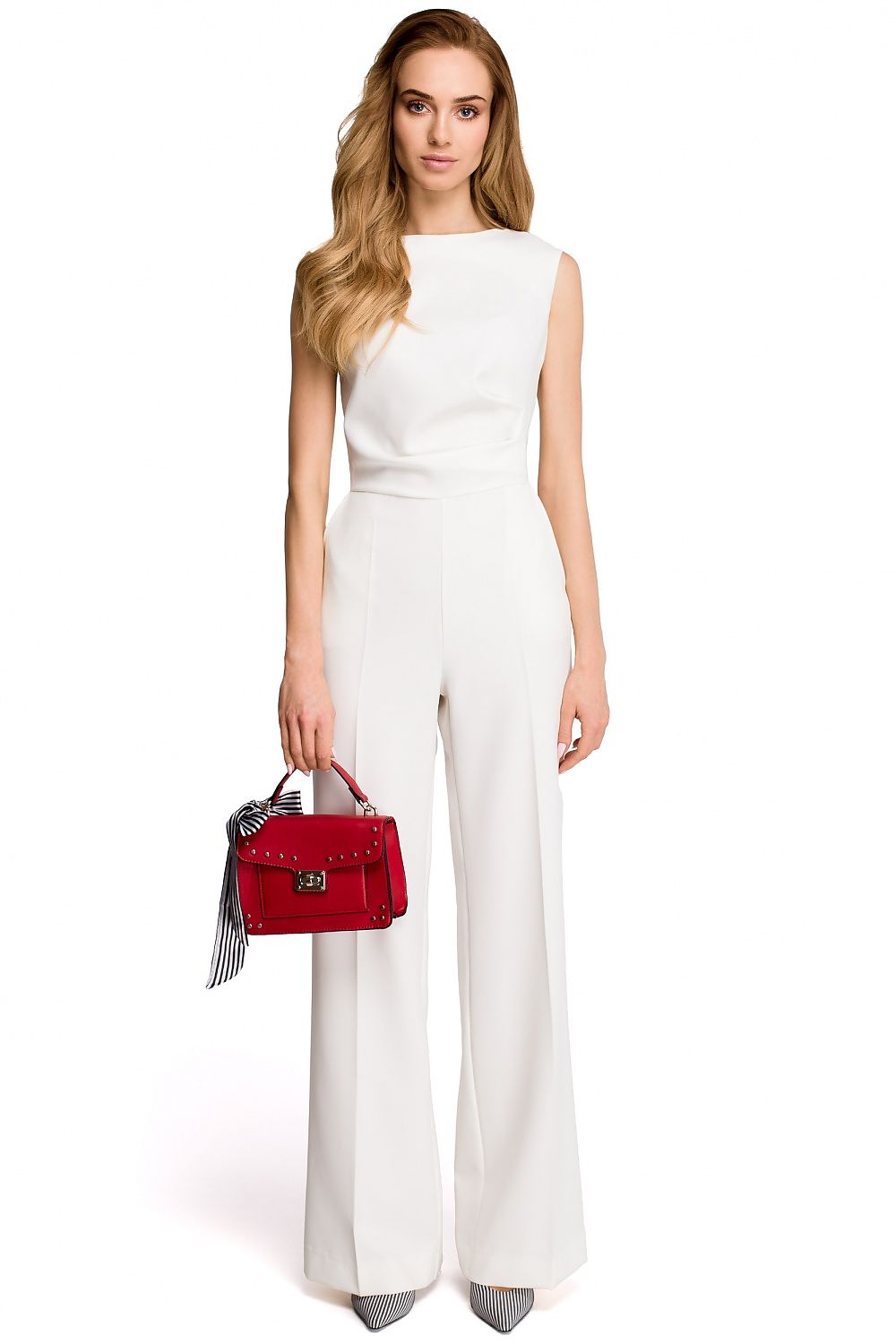 Woman in a white outfit holding a red handbag on a white background
