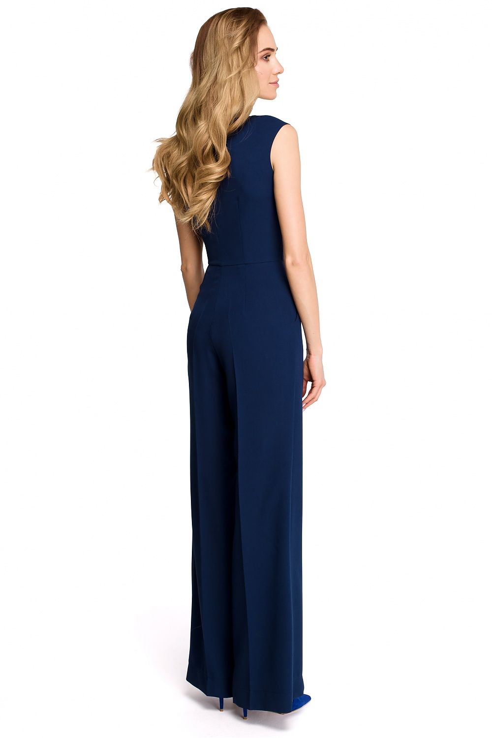 Woman wearing a navy blue sleeveless jumpsuit on a white background