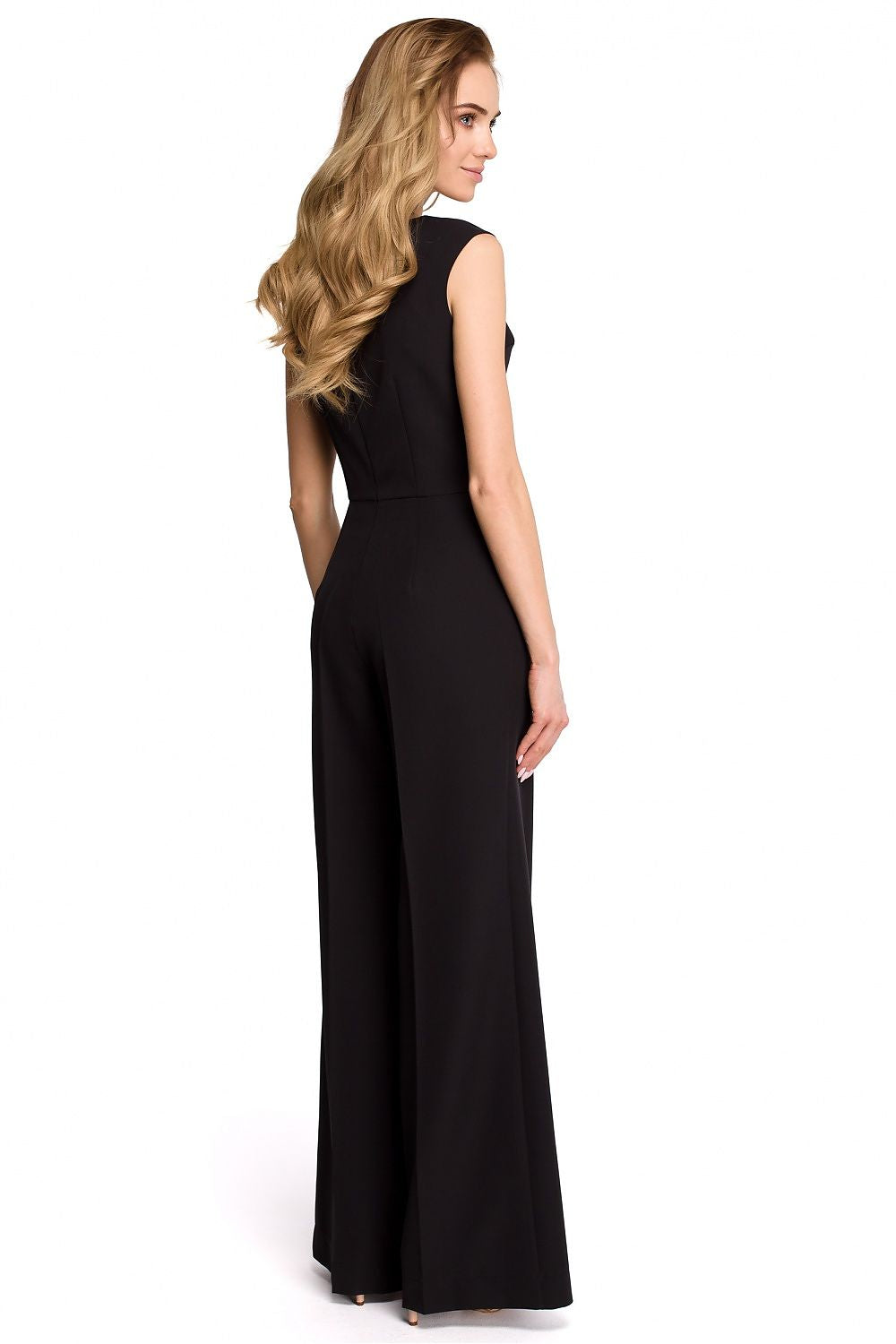 Woman wearing a black sleeveless jumpsuit on a white background