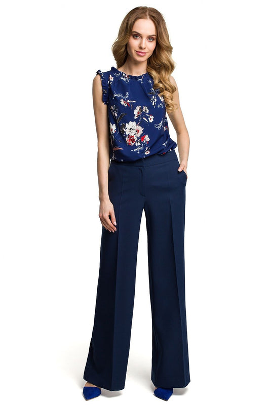 Woman wearing a blue floral top and matching pants on a white background