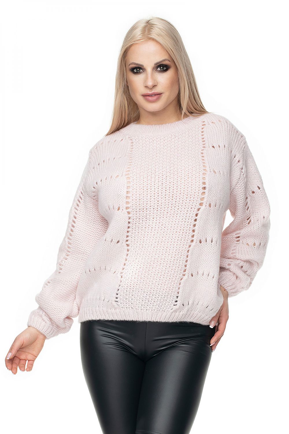 Woman wearing a light pink sweater and black pants on a white background