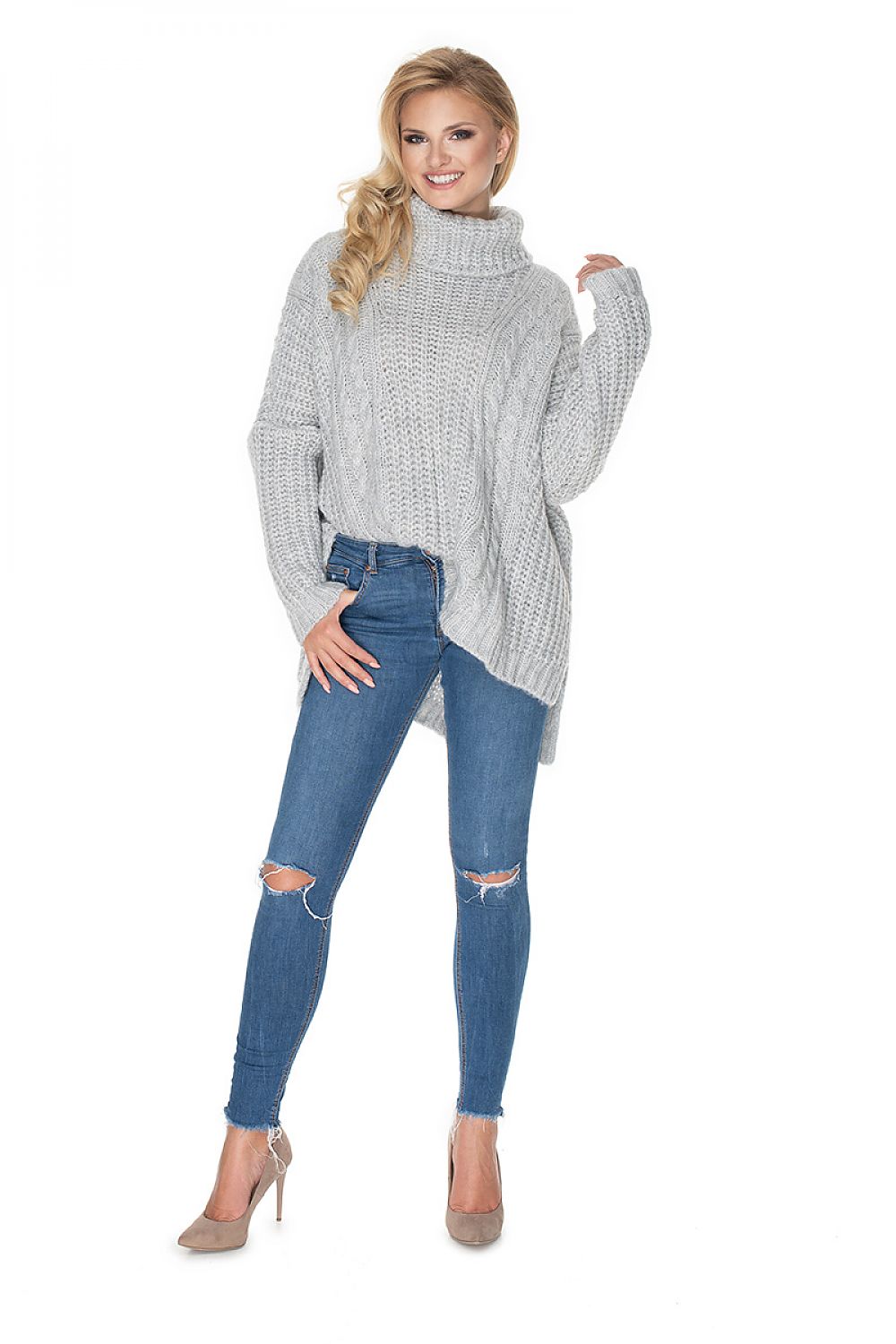 Woman wearing a gray oversized sweater and blue jeans on a white background