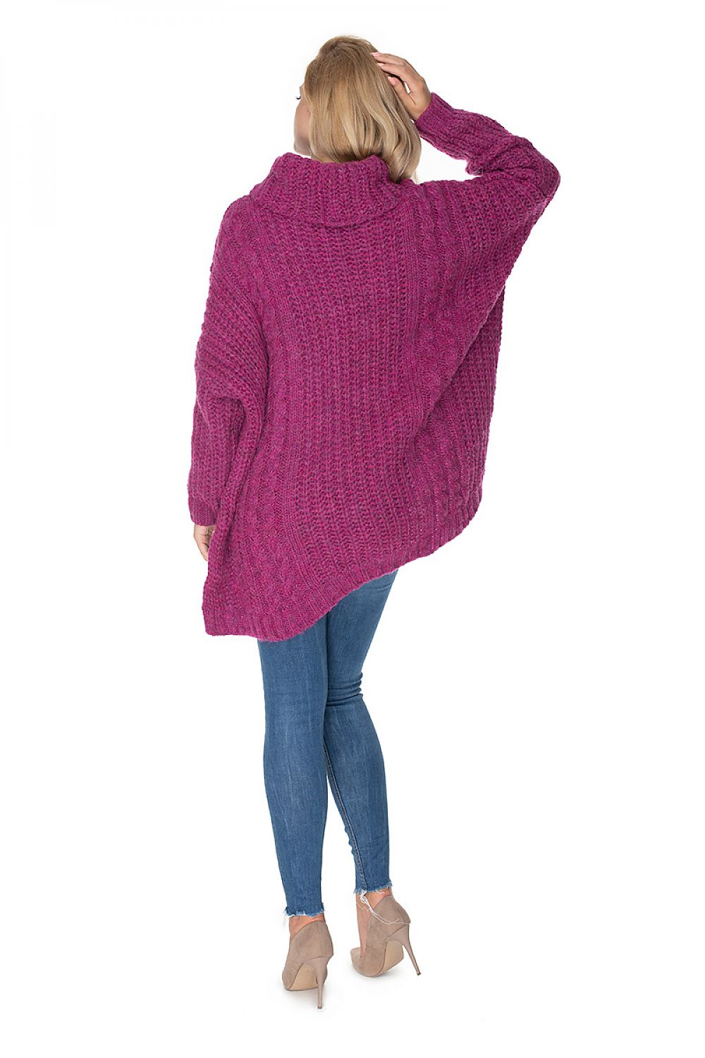 Person wearing a pink knitted sweater and blue leggings on a white background