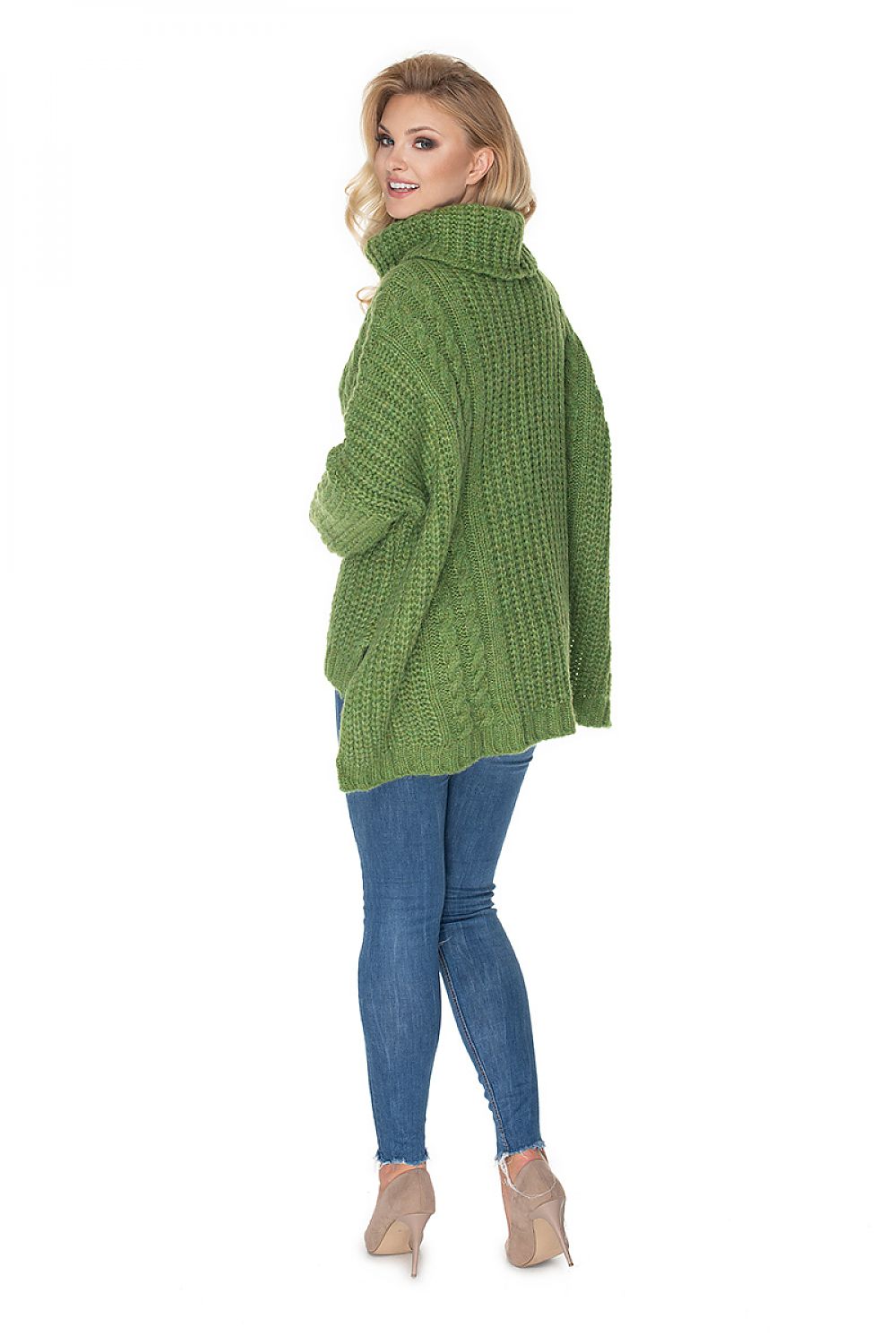Woman wearing a green knitted sweater and blue jeans on a white background