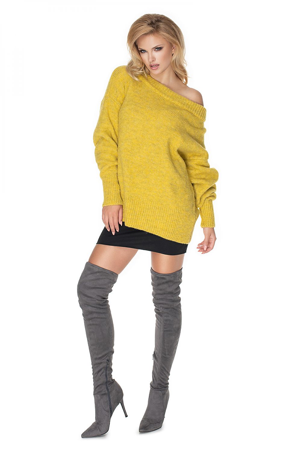 Woman wearing a yellow sweater and gray knee-high boots on a white background