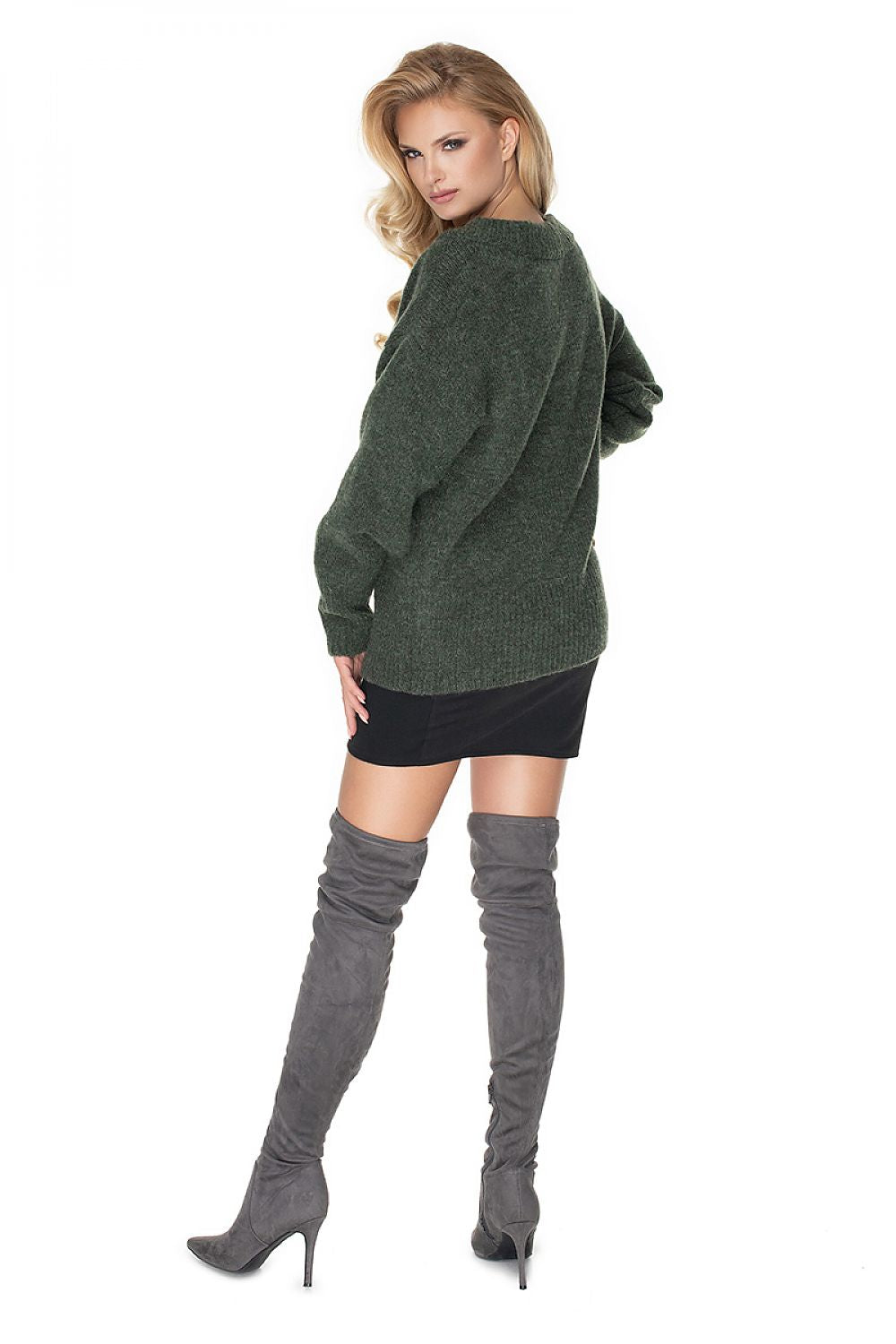 Woman wearing a green sweater and gray knee-high boots on a white background