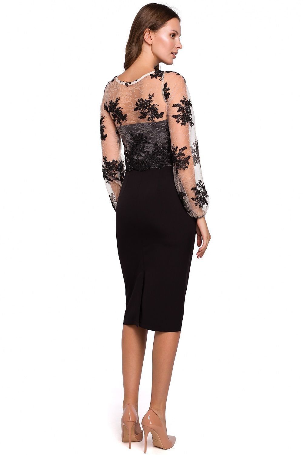 Woman wearing a black dress with floral lace sleeves on a white background