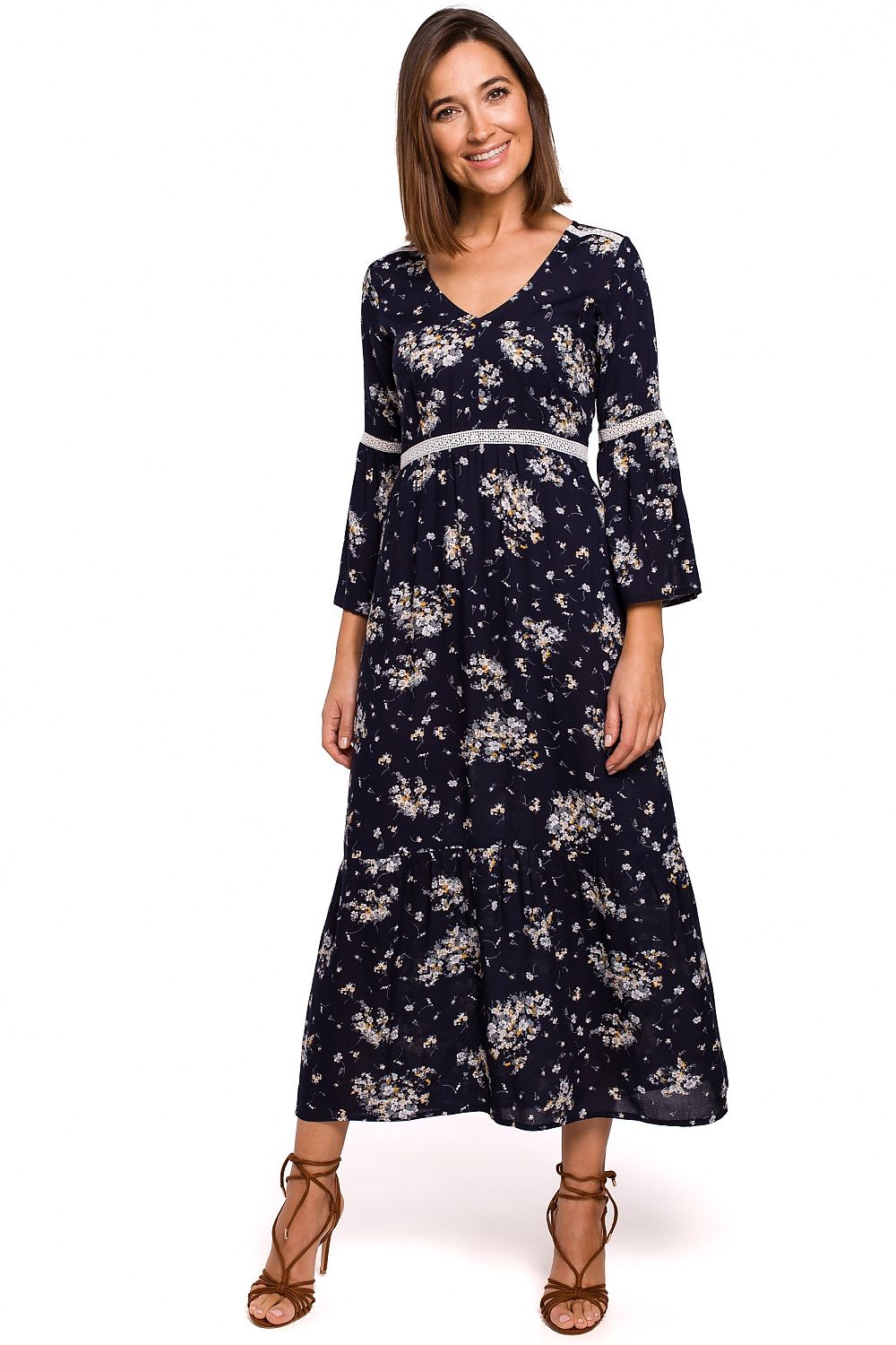 Woman wearing a navy floral dress on a white background