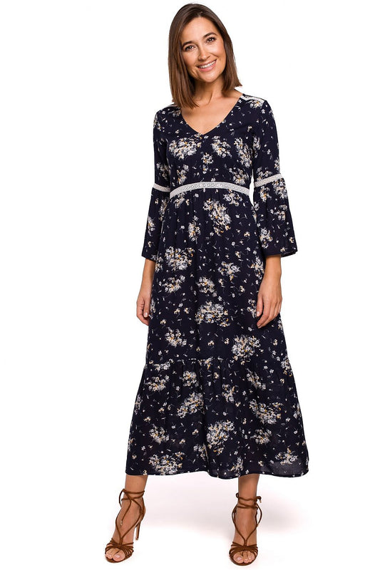 Woman wearing a navy floral dress on a white background