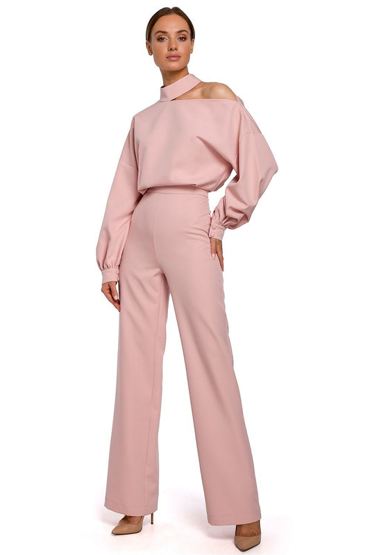 Woman wearing a pink off-shoulder top and high-waisted pants on a white background