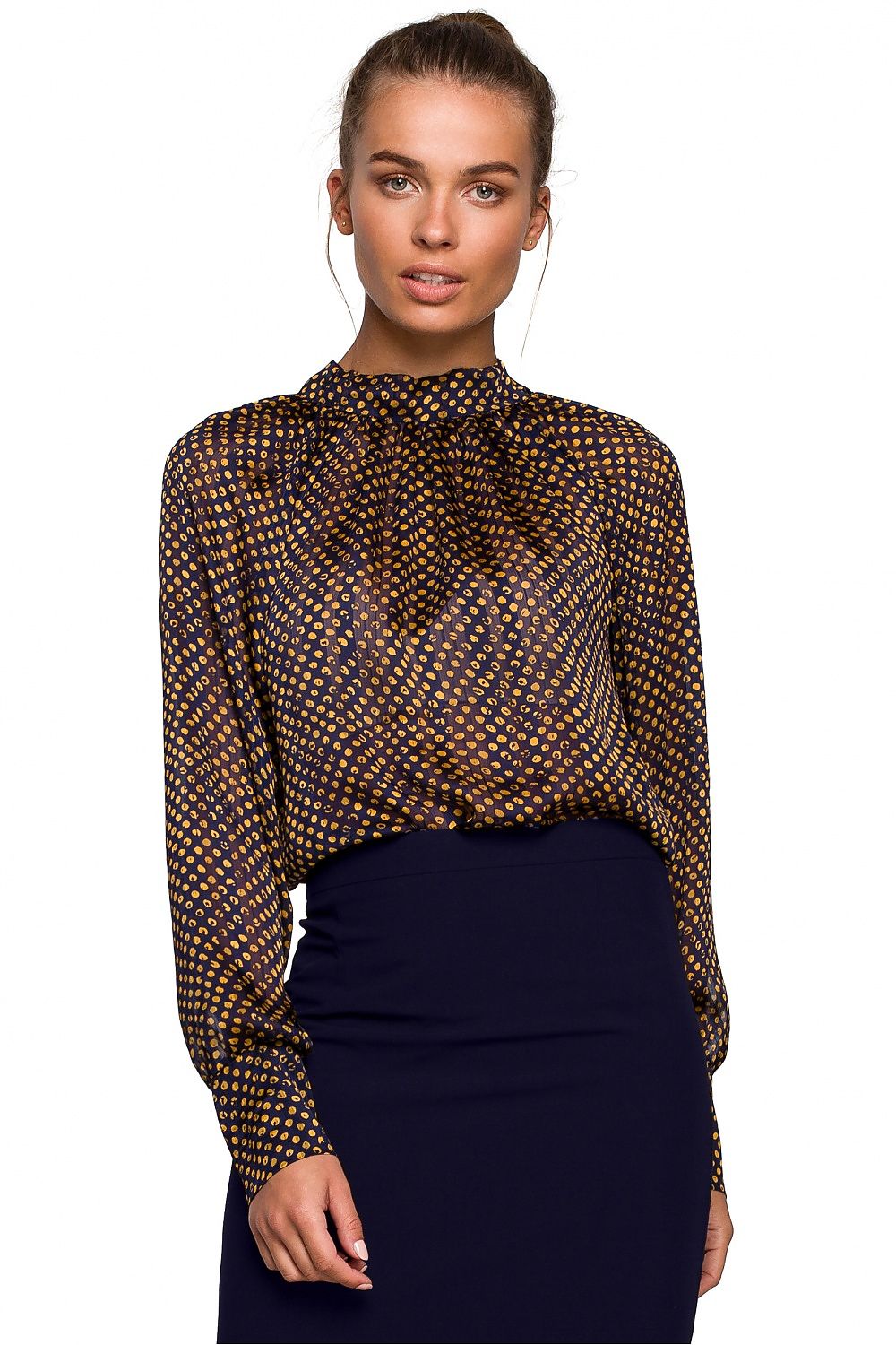 Woman wearing a patterned blouse and dark skirt on a white background