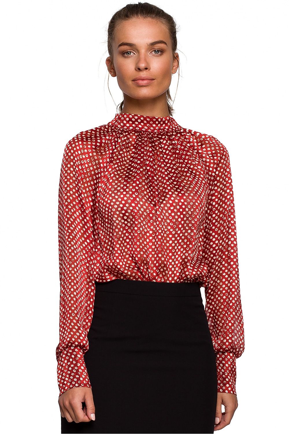 Woman wearing a red polka dot blouse against a white background
