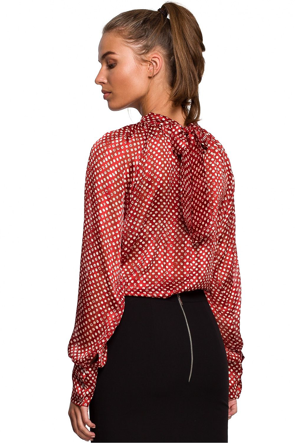 Woman wearing a red polka dot blouse on a white background