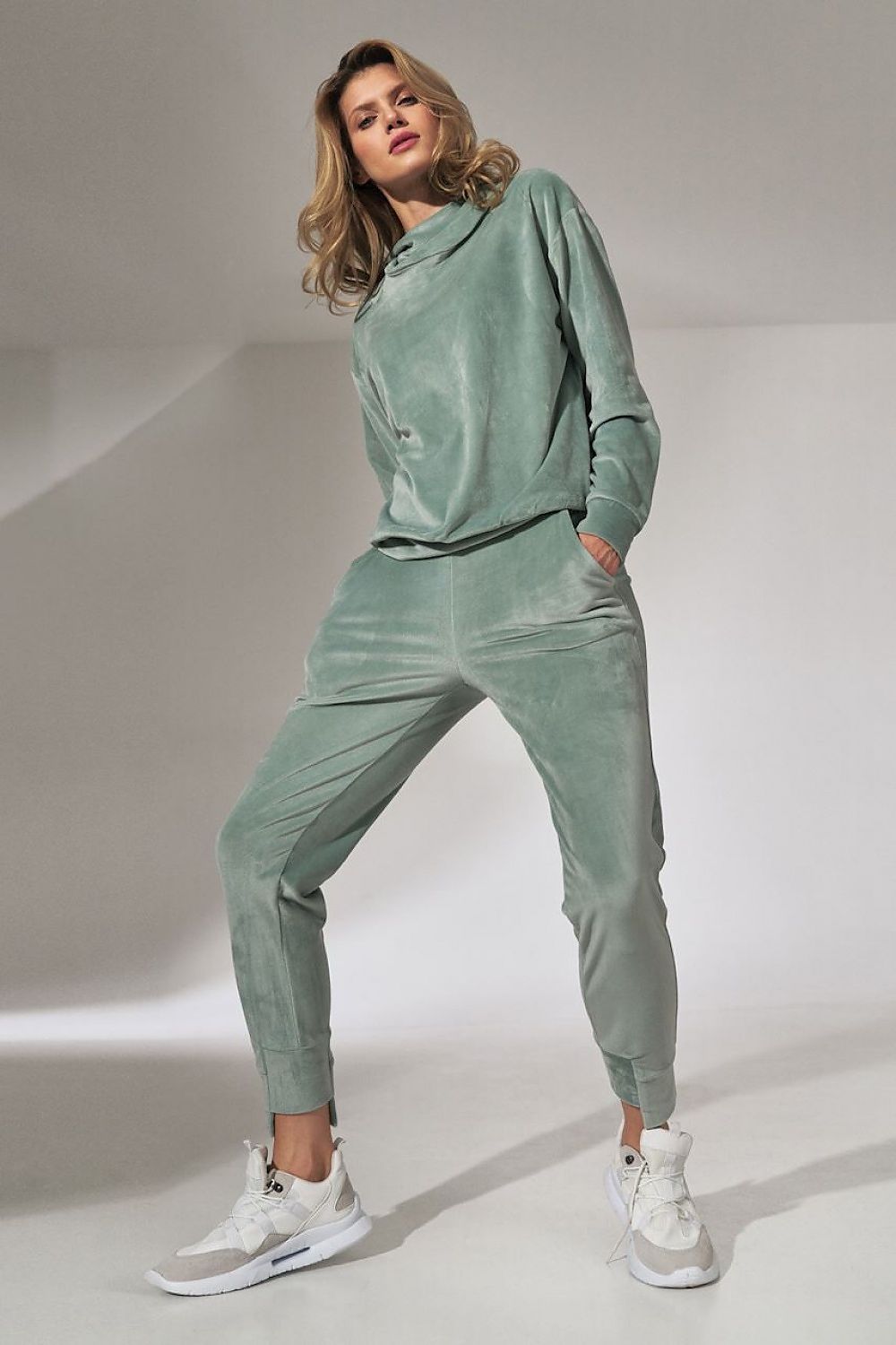 Woman wearing a green tracksuit on a white background