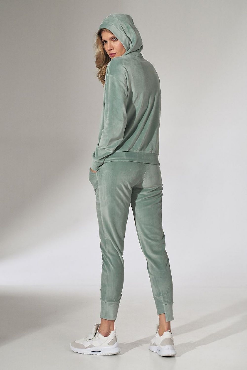 Woman wearing a green tracksuit on a white background
