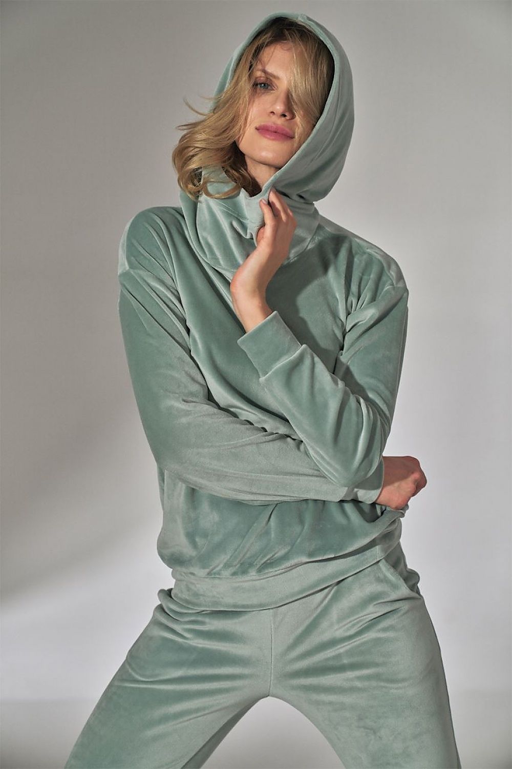 Person wearing a light green tracksuit against a plain background