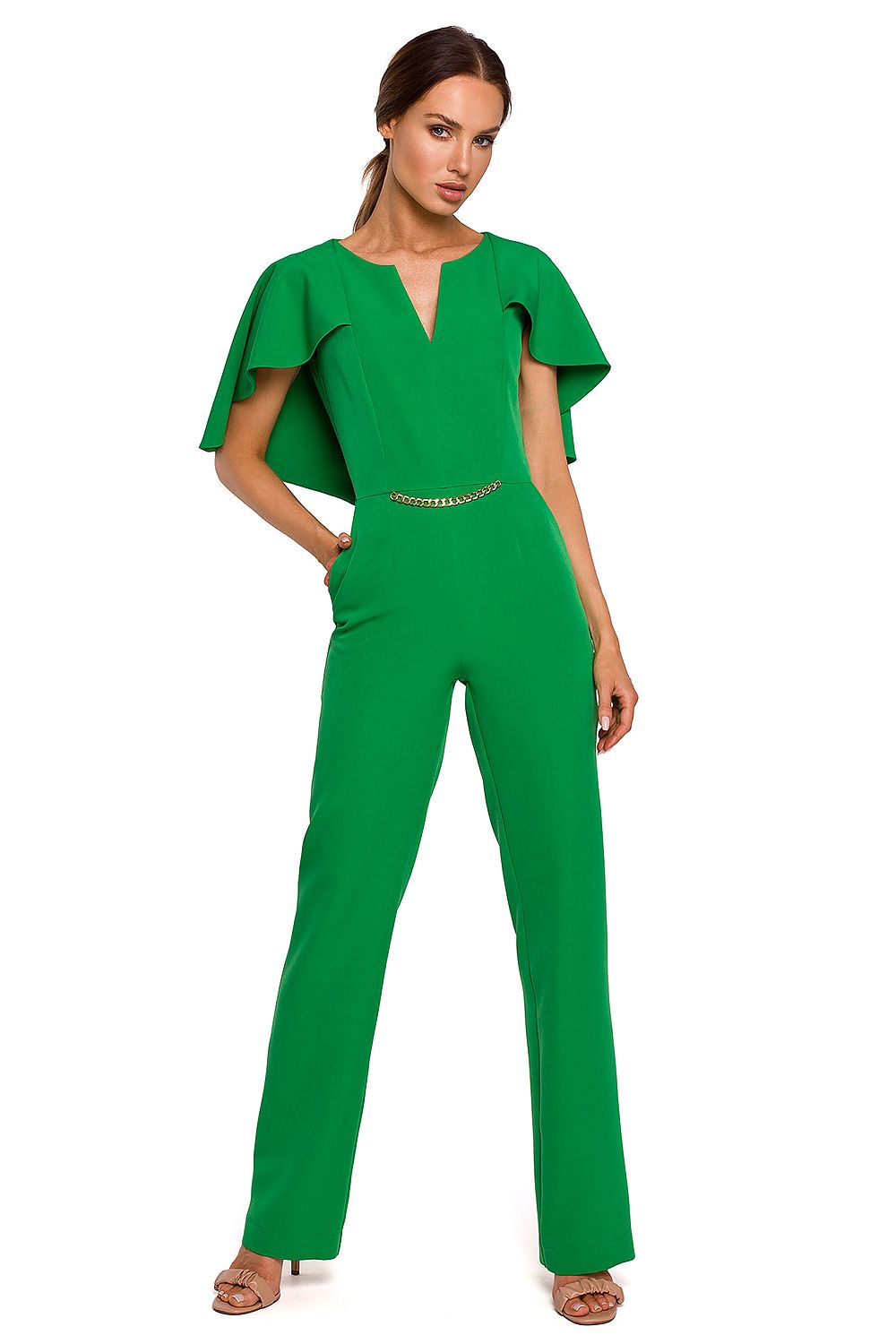 Woman wearing a green jumpsuit with ruffled sleeves on a white background
