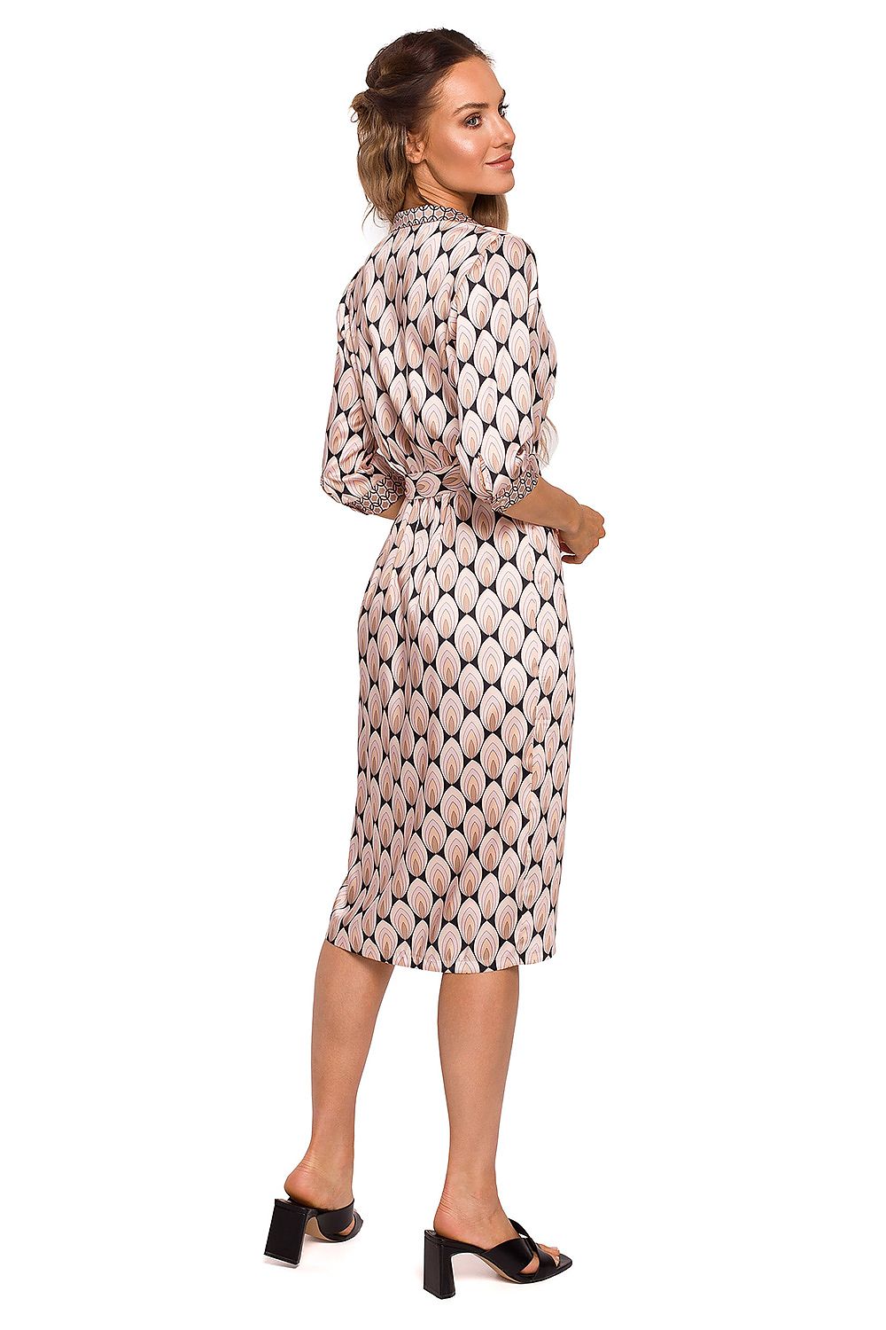 Woman wearing a patterned dress on a white background