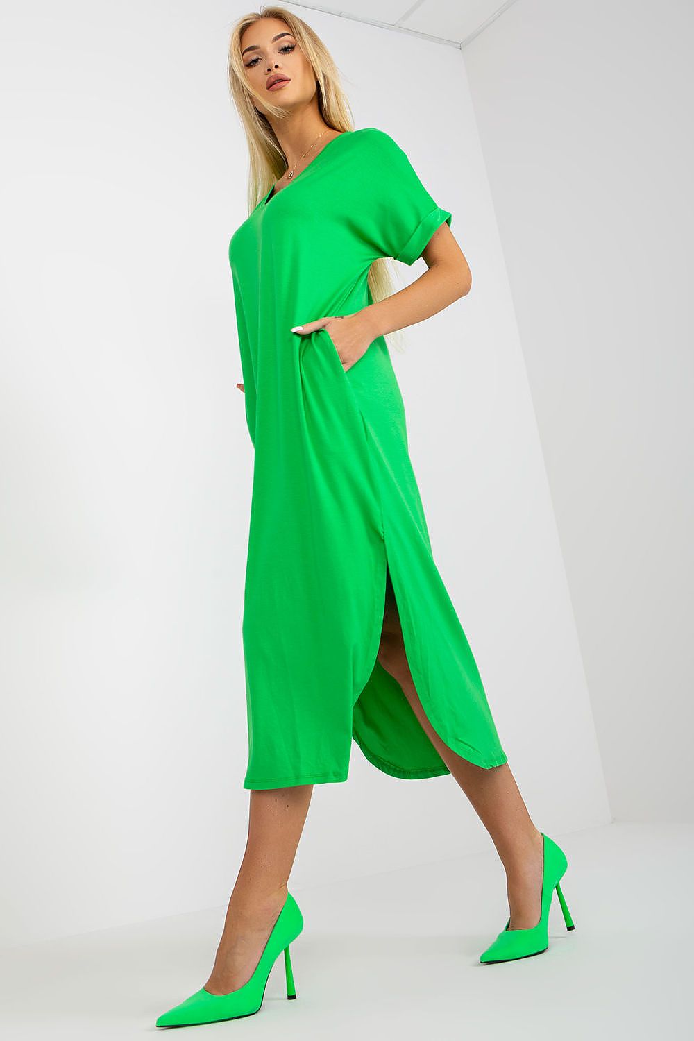Woman wearing a green dress with high heels on a white background