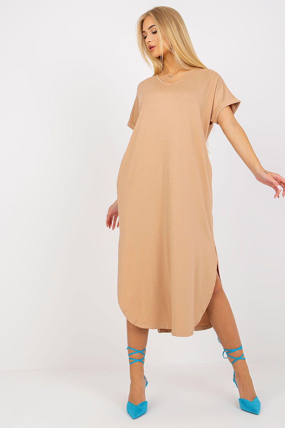 Woman wearing a beige dress with blue shoes on a white background
