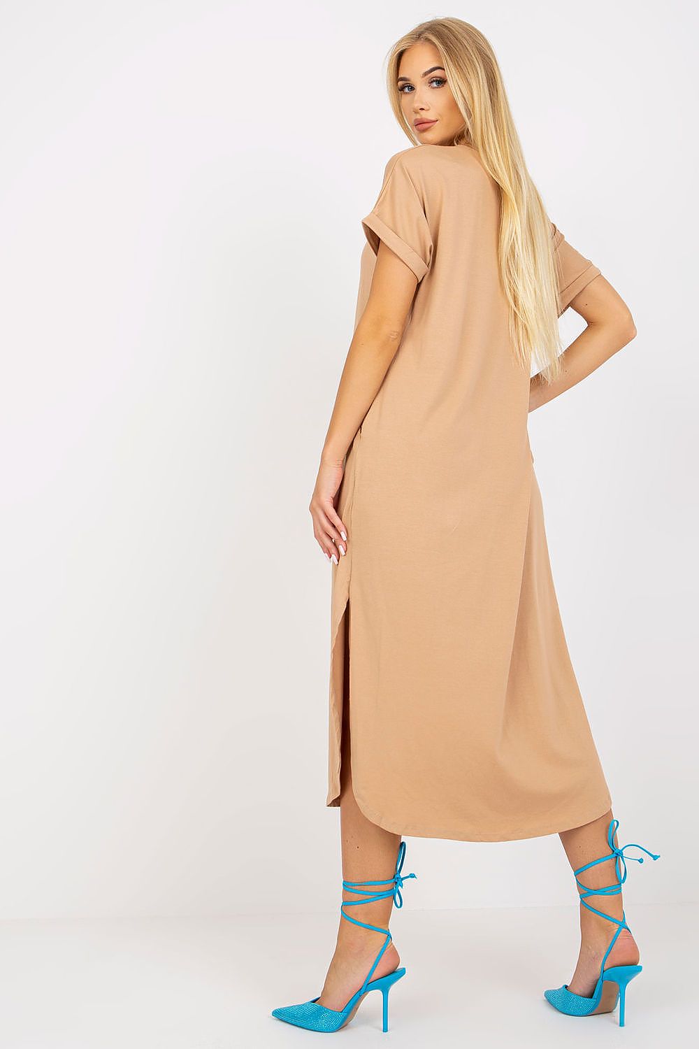 Woman wearing a beige dress with blue high-heeled shoes on a white background