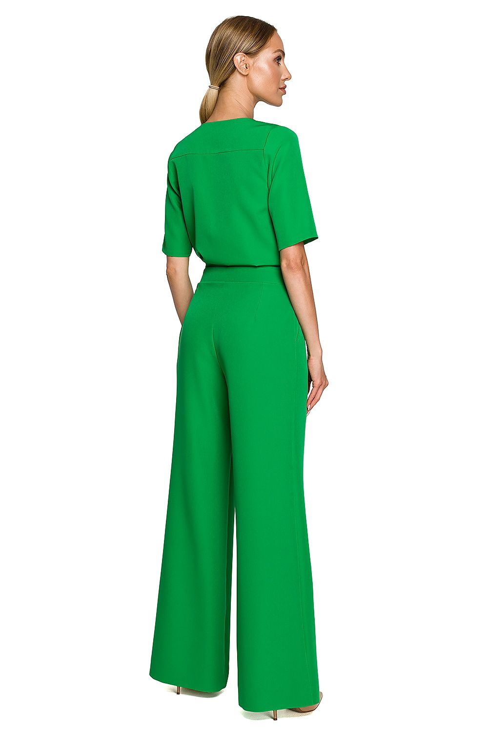 Woman wearing a green jumpsuit on a white background