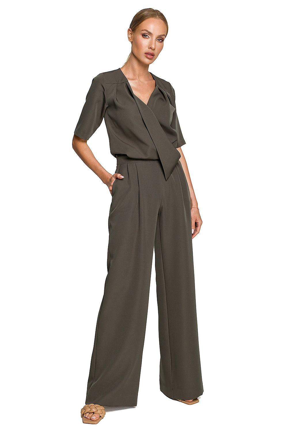 Woman wearing a brown jumpsuit on a white background