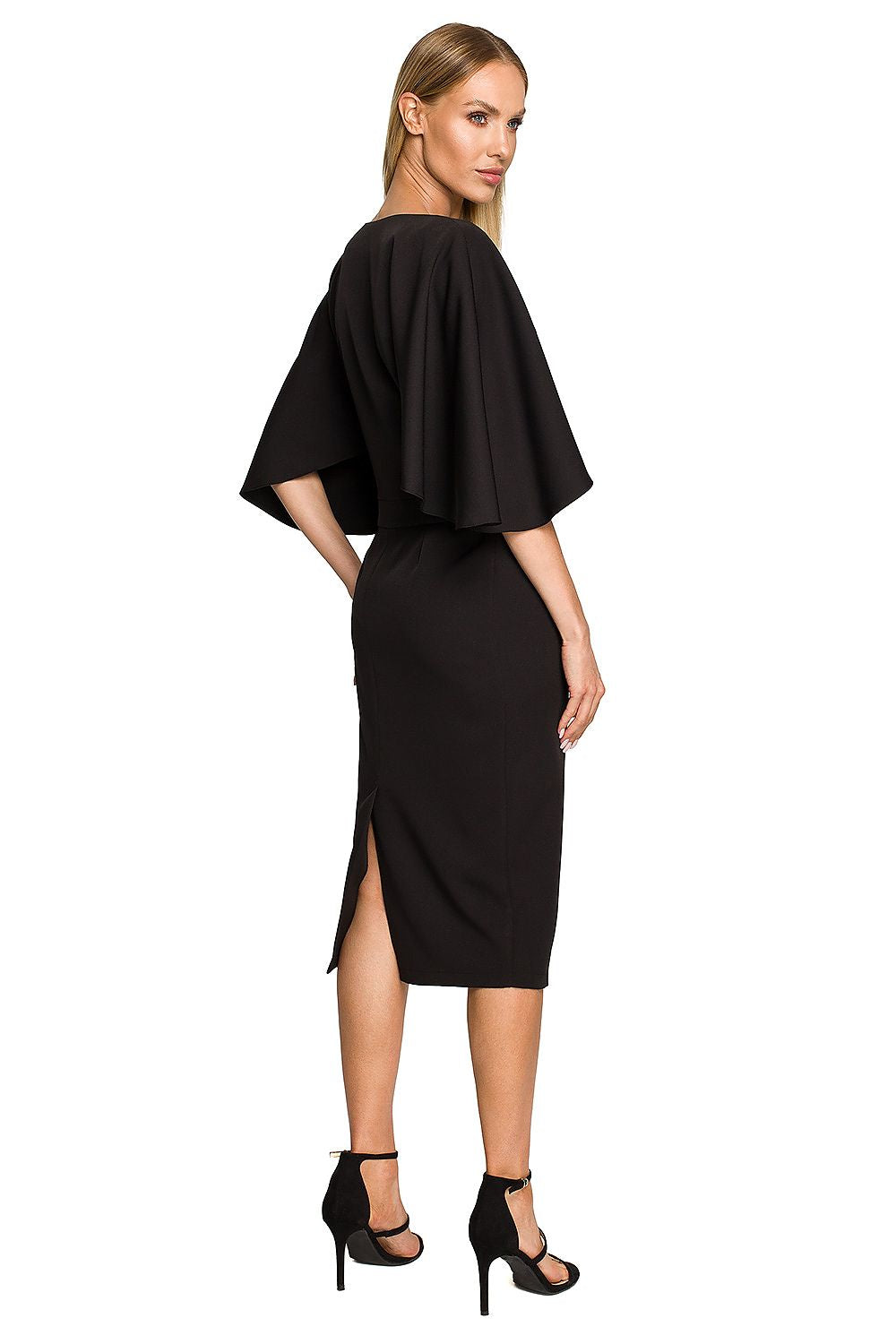 Woman wearing a black dress with a slit on a white background