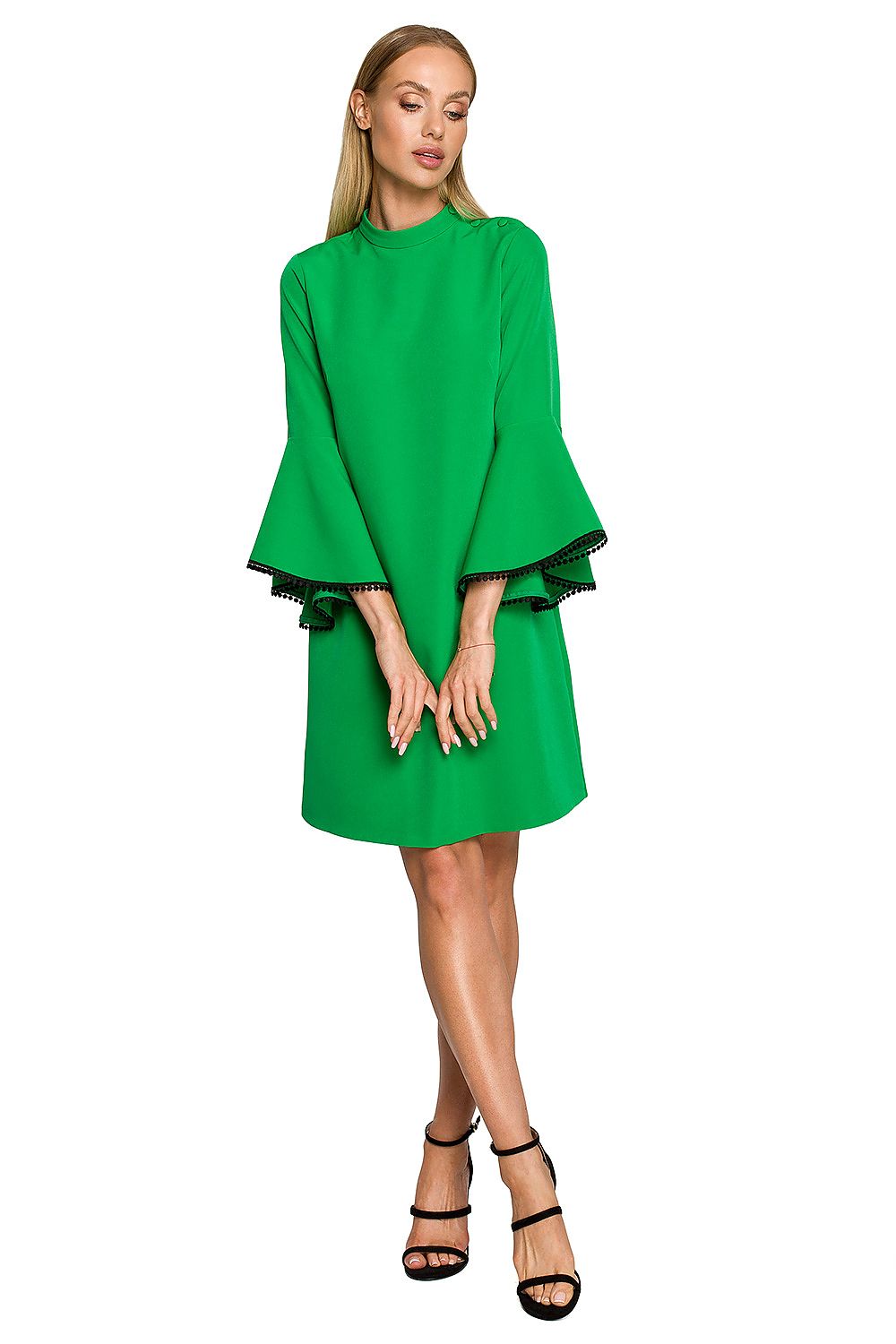 Woman wearing a green dress with ruffled sleeves on a white background